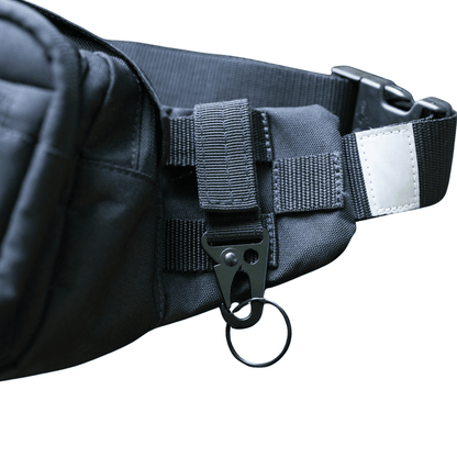 Person zeigt die Anwendung des Metallkarabiner an der TamBe Bag
